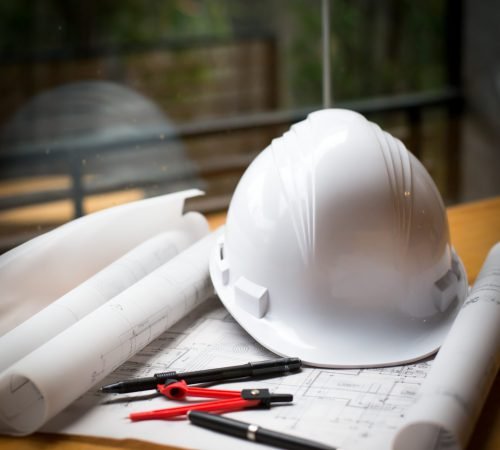 construction concept image helmet rolled blueprints on wooden boards in retro style.